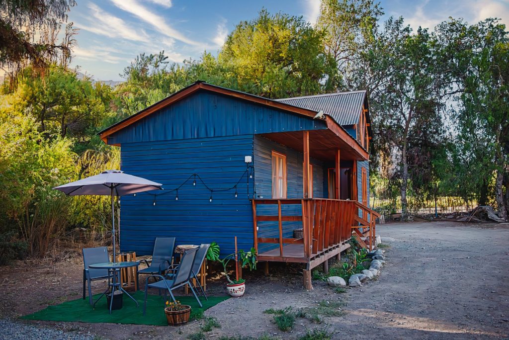 Cabaña azul con terraza de madera
